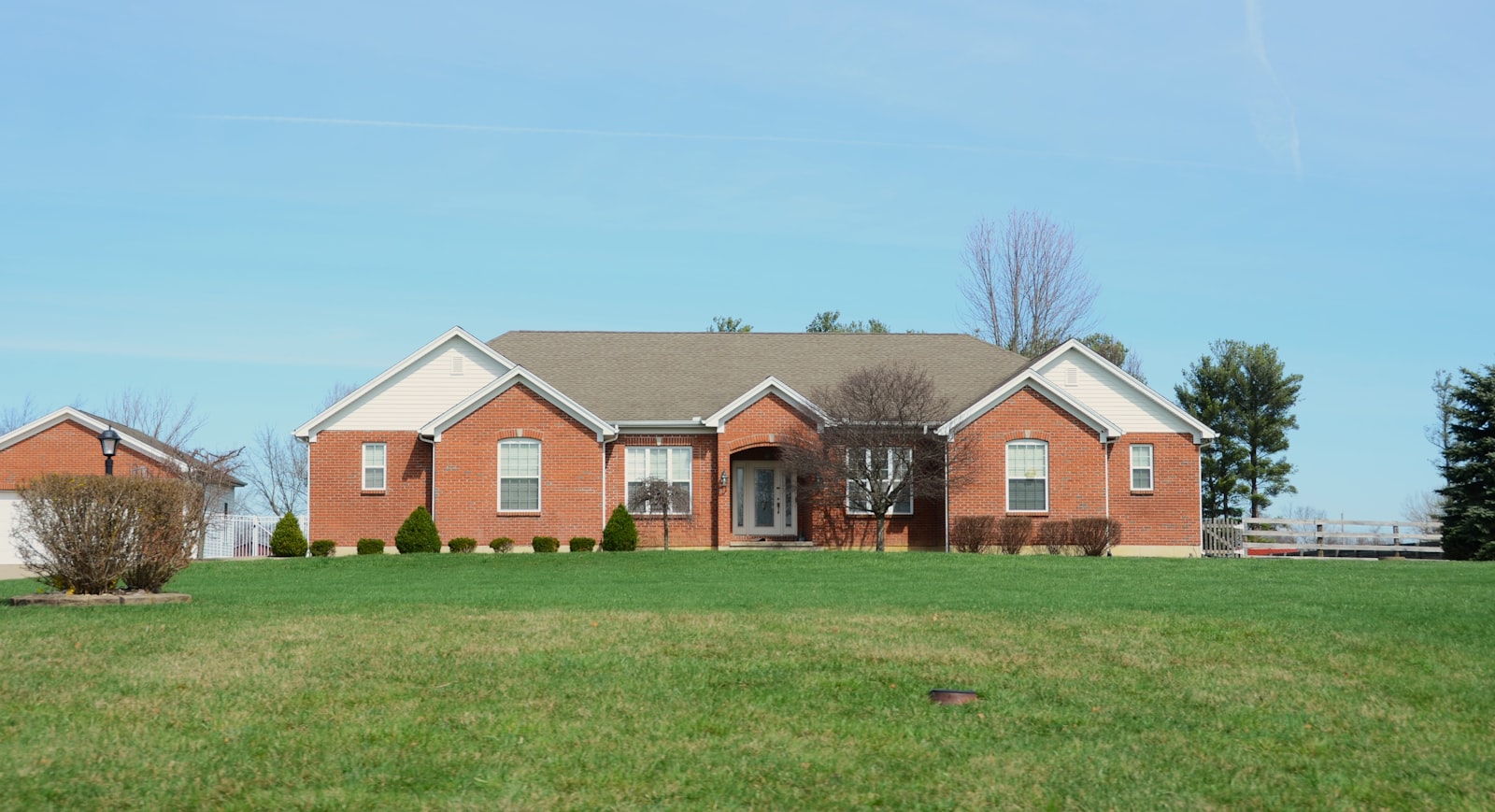Brick Forney-style two-story home with a freshly mowed and edged front lawn.
